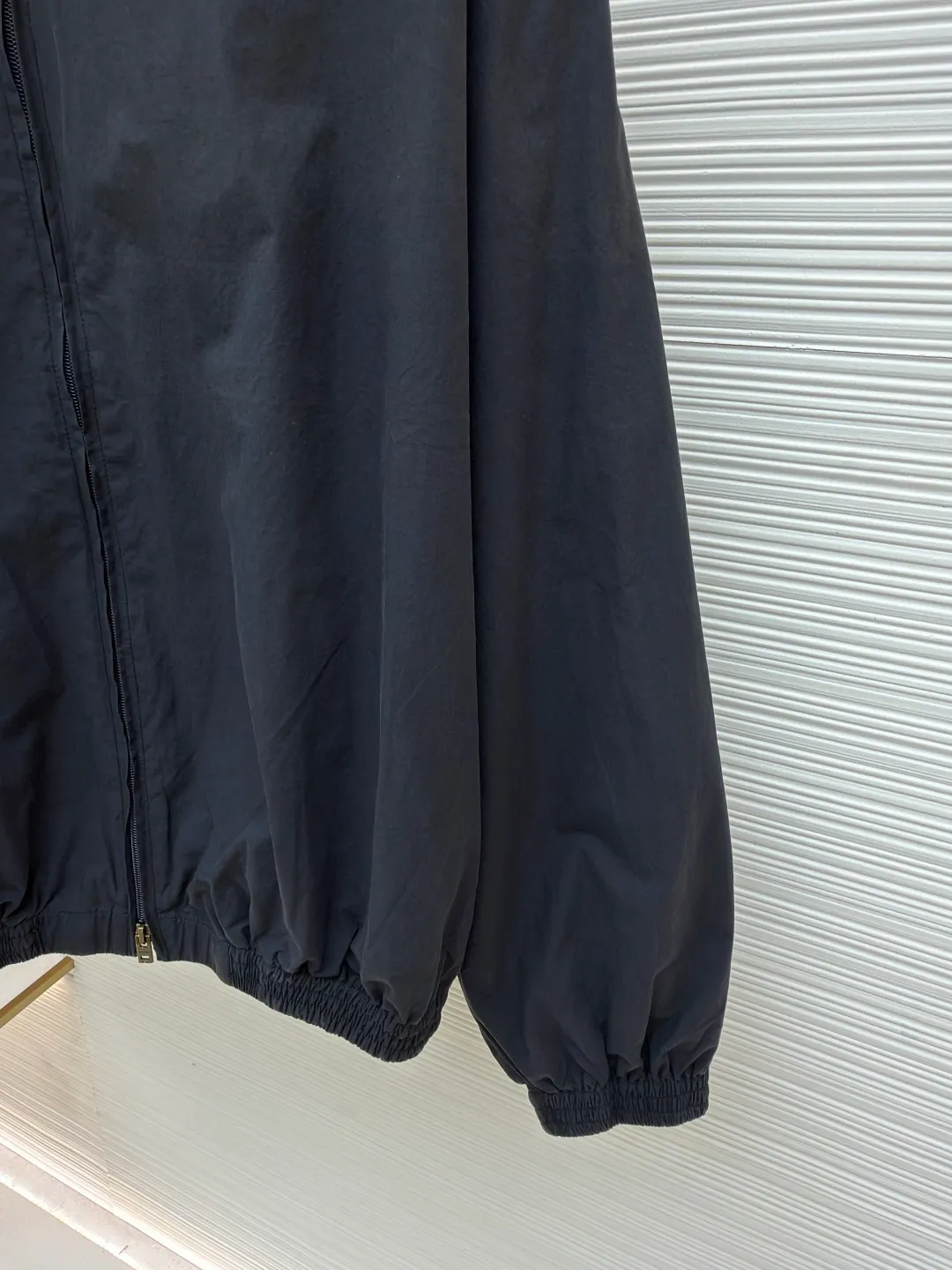 Acne Studios contrasting logo zipper jacket ●Original version: Purchased and developed for 6500 ●Item number: 1681084-B45 ●Material: Illusion elegant cotton fine woven silk fabric ●Technology: Solid printing production ●Version: Loose fit ●Weight: about 600 grams ●Size: 42-44-46-48 ●Description: Customized Illusion elegant cotton fine woven silk, soft and silky, comfortable and close to the skin, with aged black as the color The inadvertently smudged distressed effect meets the carrier of retro sentiments. The panel decorations are displayed in a homogeneous manner. It is embellished with the eye-catching Acne Studios 1996 contrasting logo on the back panel. It has a retro charm and exudes a modern simple fashion sense. The elastic cuffs and hem design cleverly outline the body lines and reveal a sense of high-end that cannot be ignored in the casualness. It is the most stylish fashion pioneer on the street, using solid printing. The chest printing has been modified by the film screen three times. Use glue liquid paint to print the pattern on the fabric, bake the fabric to fix the printed pattern, and use the gradient spraying process to make the clothes appear rich in color under different lights and increase the visual layering. Heavy washing uses a special solution to remove stains and slight fading, and then snowflake washing uses strong washing to remove fading and make the color more uniform. The hem is made at one time using a three-needle waist-stretching machine. The machine's special needle position and feeding mechanism are used to sew the elastic band and the fabric together in the same process. The three-needle design is stronger and can evenly distribute pressure to ensure that the elastic band and the fabric are tightly fitted. The overall wiring is straight and delicate, the fabric is comfortable and soft, and the color is consistent without color difference. It can be matched with the same style to create a fashionable look and control various occasions. Customized accessories, complete with three standards, same style for men and women!